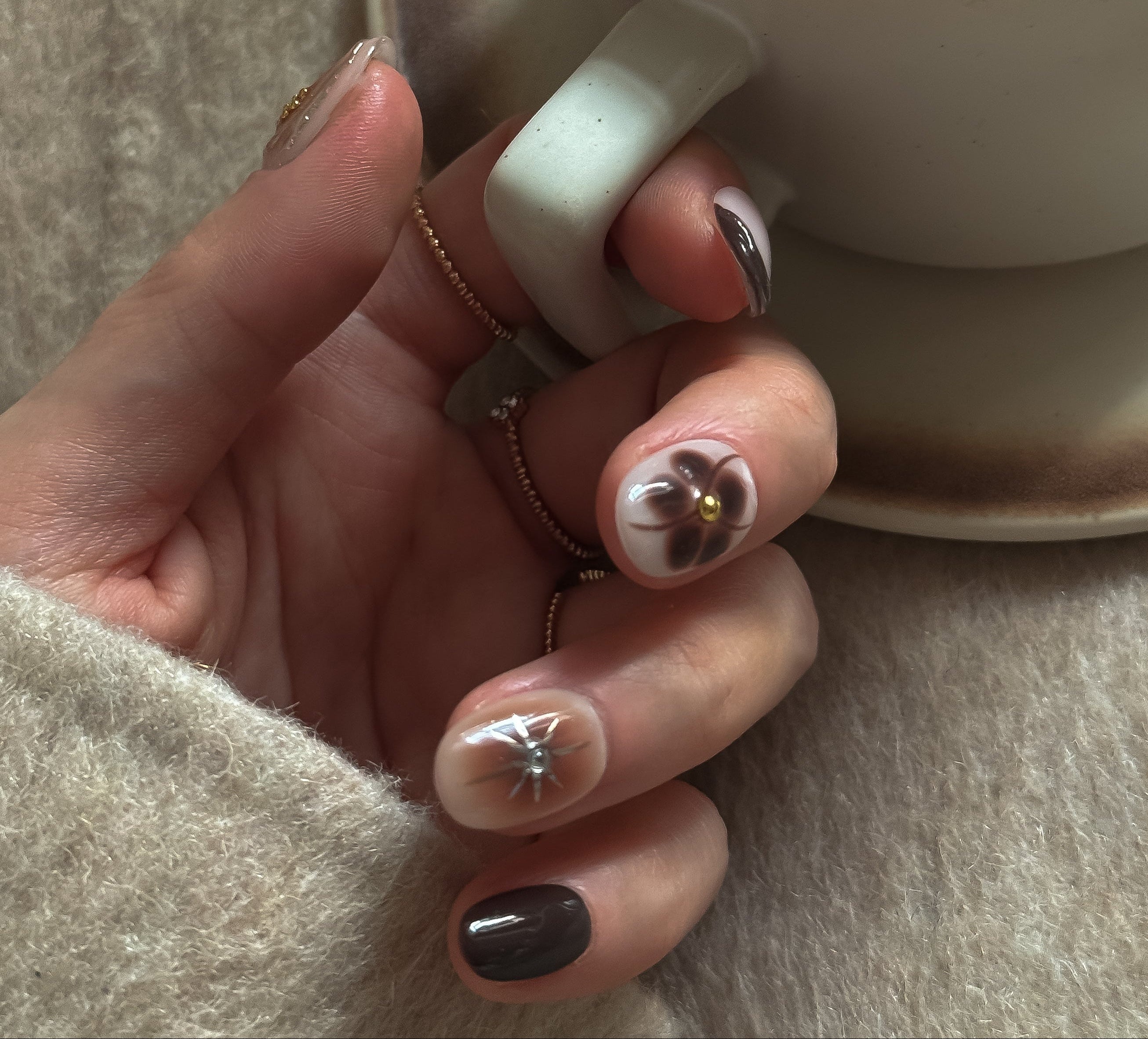 brown short almond press on nails on hand and hold a cup of coffee