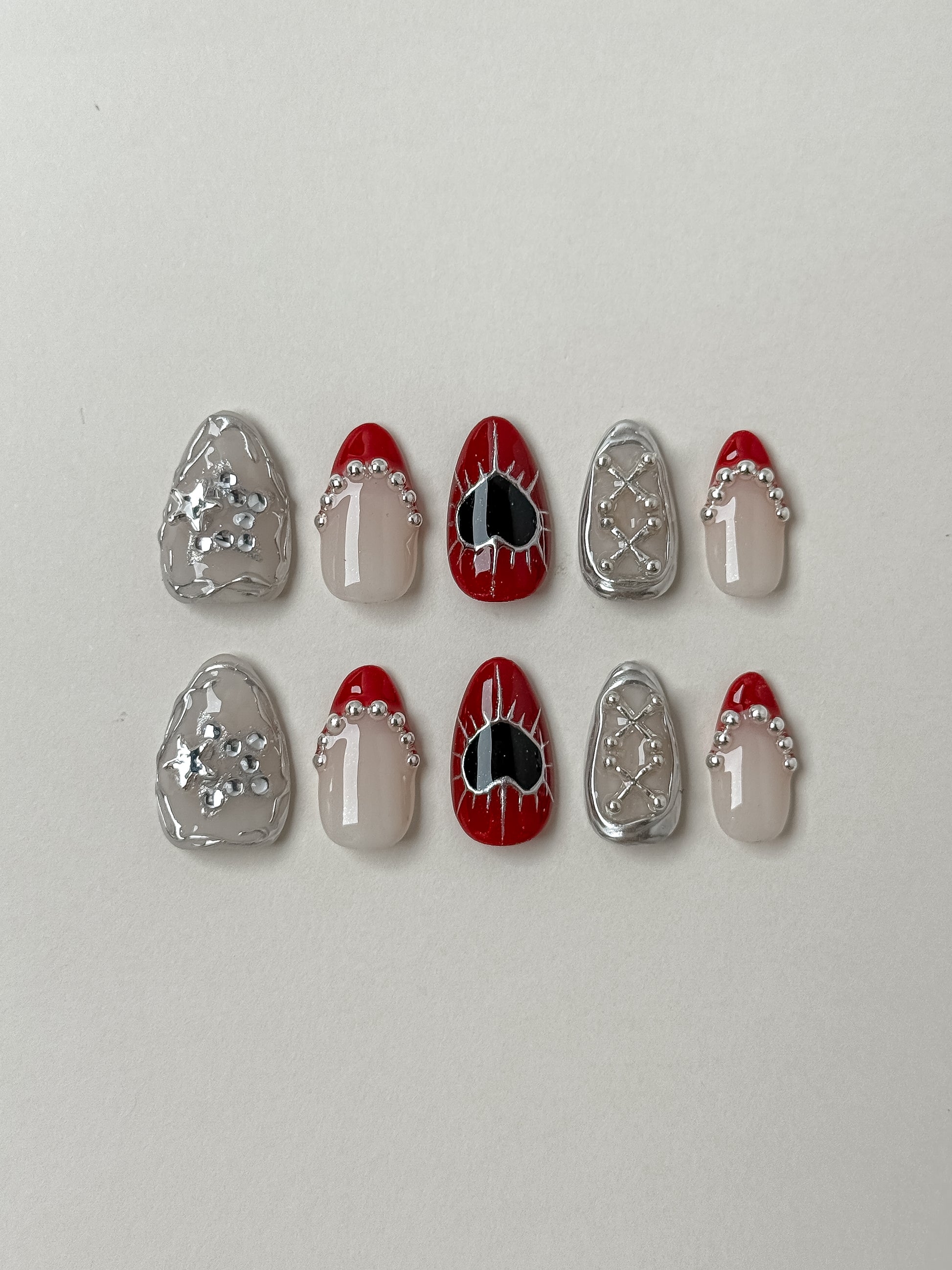 10 pcs handmade Gothic Press-On nails featuring 3D silver chrome, red french tips with corset beads, and black heart nail art.