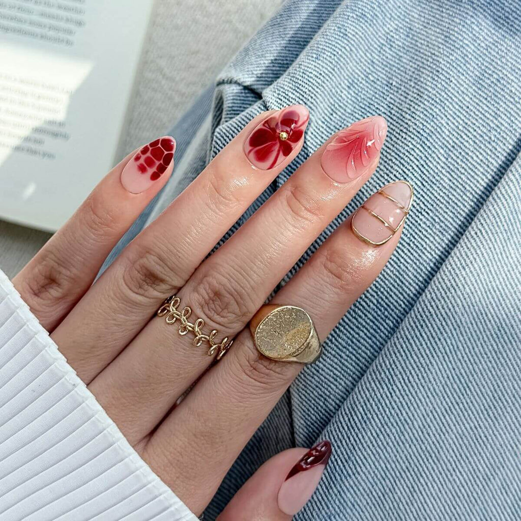 Künstliche Nägel zum Aufkleben in Weinrot und Mandelform getragen im Alltag, mit kreativen French-Tips im Schildpatt-Look und plastischer Nailart.