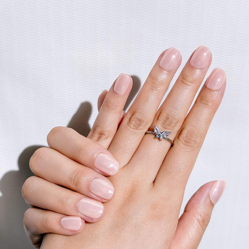Natural manicure look with Justmee Blushbare glossy nude stick-on nails, short almond shape for an elegant everyday style.