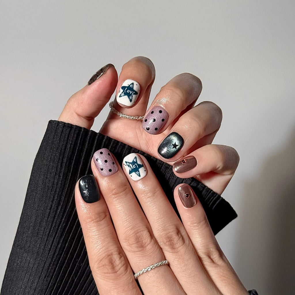 Professionelle Lifestyle-Fotografie beider Hände mit den handgefertigten Celestial Grunge Kunstnägeln, kombiniert mit minimalistischen Silberringen für einen trendigen Y2K-Look.