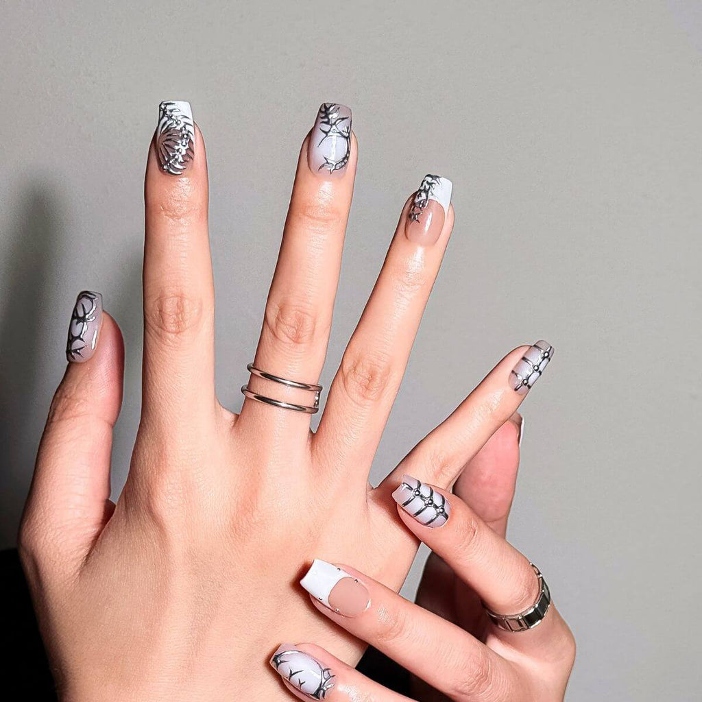 Nahaufnahme von The Starry Chrome künstlichen Nägeln von justmee an der Hand, die reflektierende silberne Chrome-Sterne und Y2K-Details zeigt.