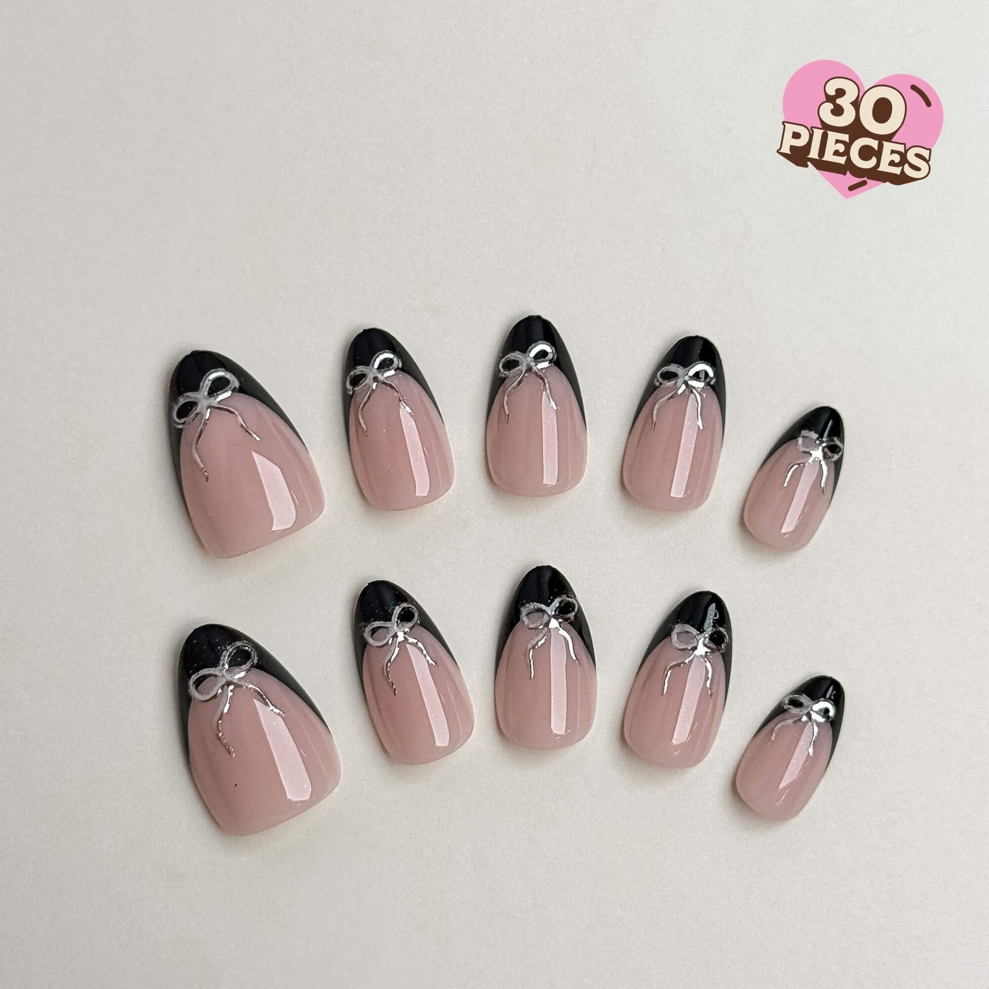 Press-on-Nägel in Mandelform mit nackter Basis, schwarzen French-Tips und silbernen Chrome-Schleifen-Details.