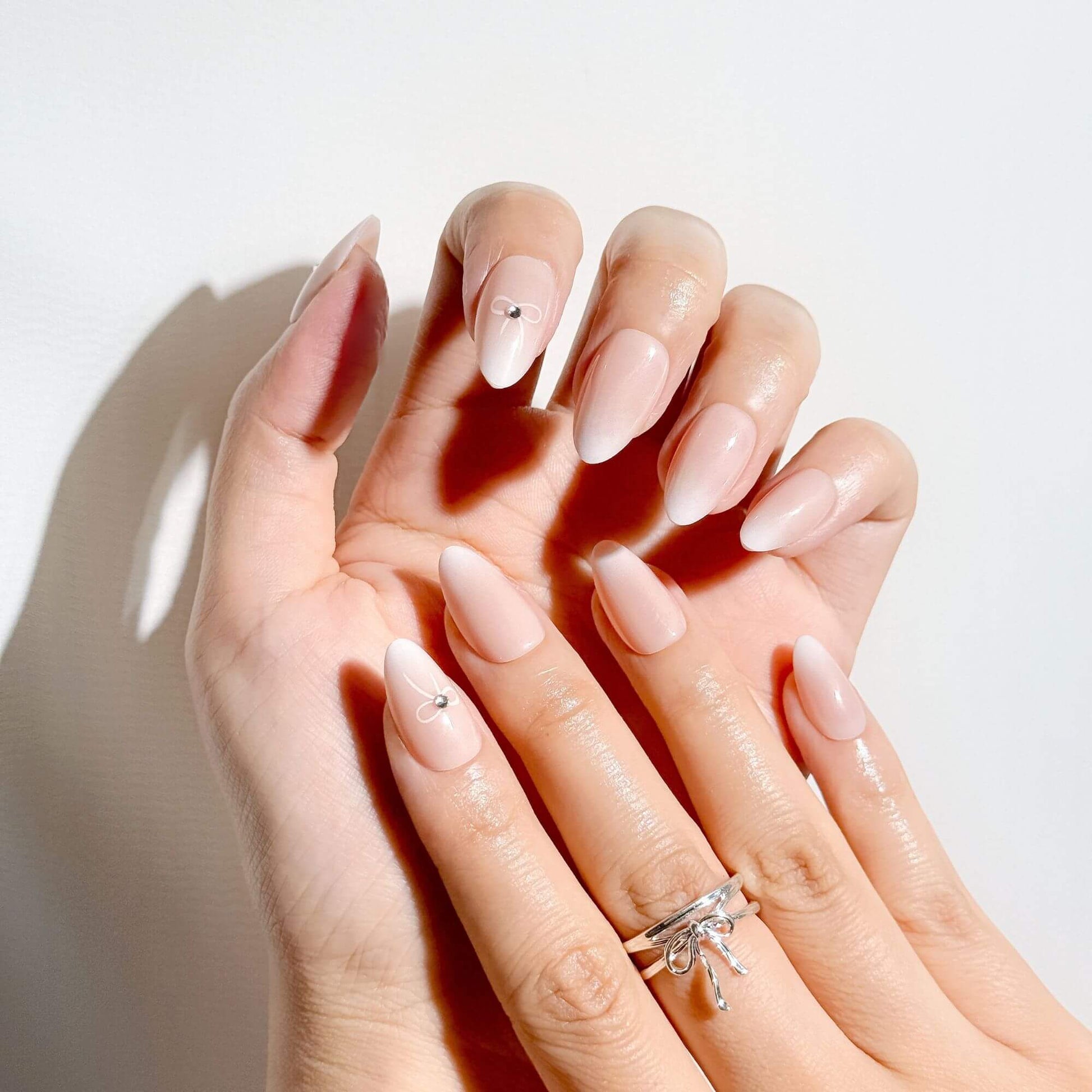 Elegante Coquette-Aesthetic Maniküre mit Justmee French Ombre Nägeln zum Aufkleben und 3D-Schleifen-Design.