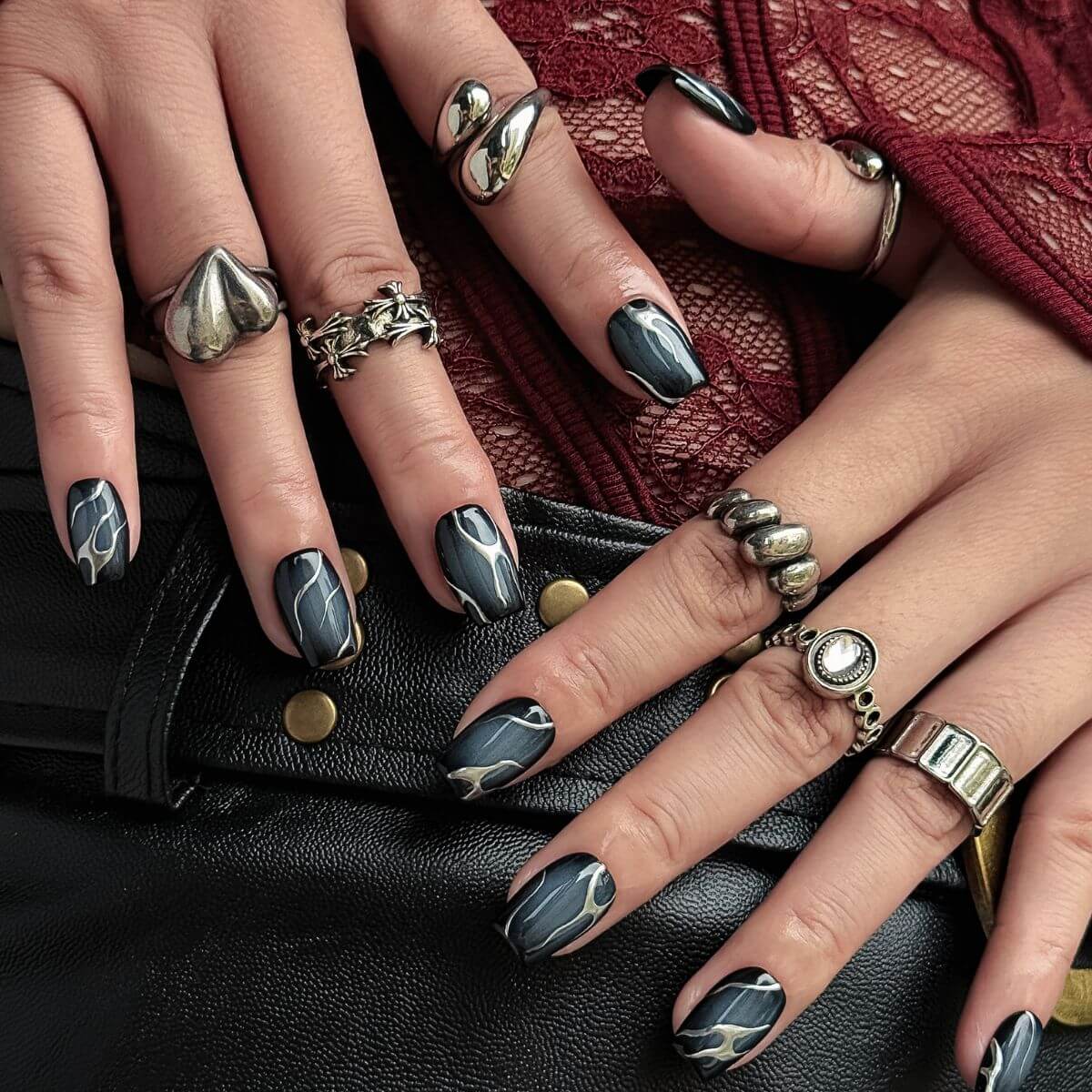 short coffin press-on nails with a smoky semi-translucent black quartz base and organic metallic silver flame-like liquid lines.