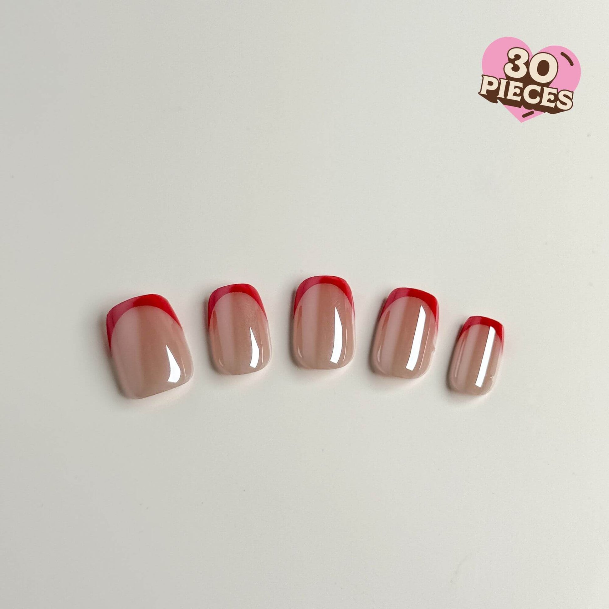 Close-up display of five Justmee press-on nails with thin red French tips and a glossy nude base, highlighting the modern and clean design.