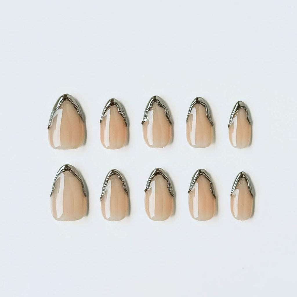 Flatlay von The Chrome French Kunstnägeln. Nude Gel-Basis mit 3D Chrome-Drip-Spitzen für eine moderne Interpretation der French Nails.