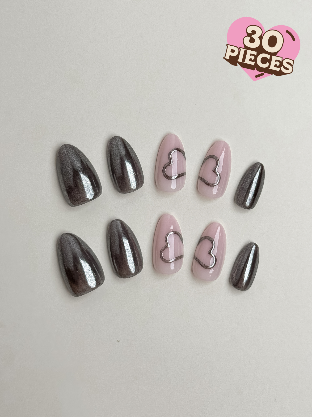 30-piece almond press-on nail set featuring gunmetal chrome and pink heart outline art. Medium almond shape and reusable.
