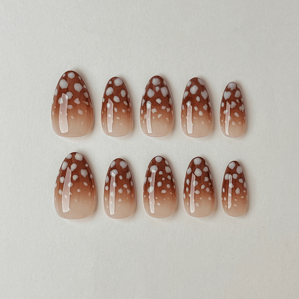 Handgemachte Press-On Nägel in Mandelform mit braunem Ombré-Farbverlauf und gepunktetem Rehkitz-Muster.