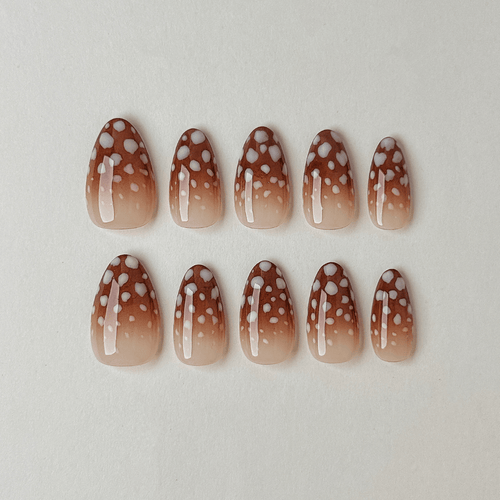 Handgemachte Press-On Nägel in Mandelform mit braunem Ombré-Farbverlauf und gepunktetem Rehkitz-Muster.