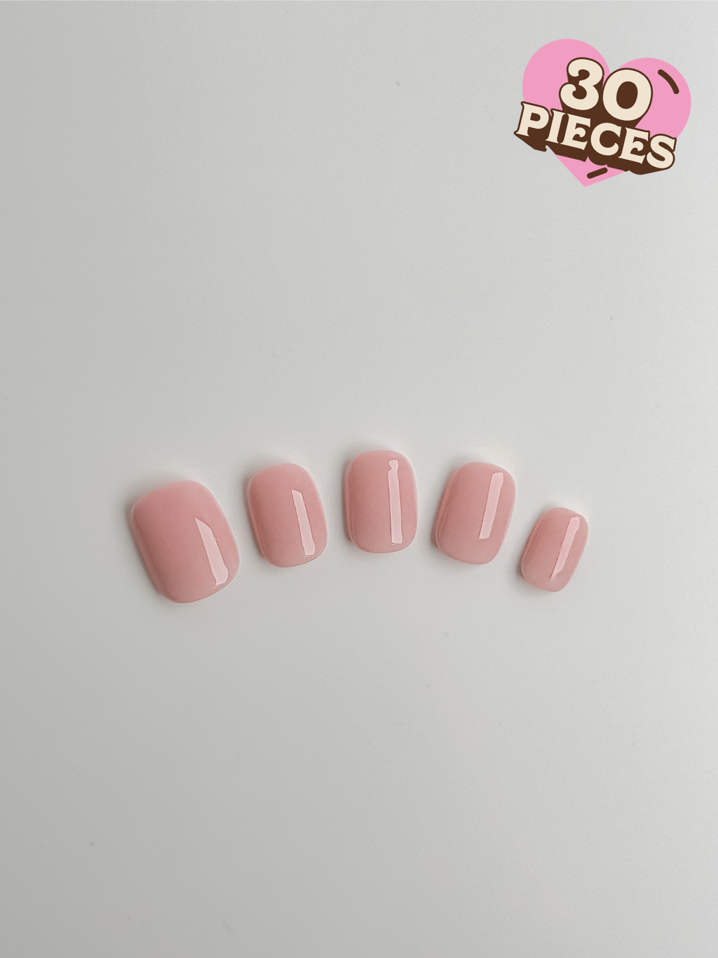 Five short square press-on nails in a translucent strawberry milkshake pink with a high-gloss finish
