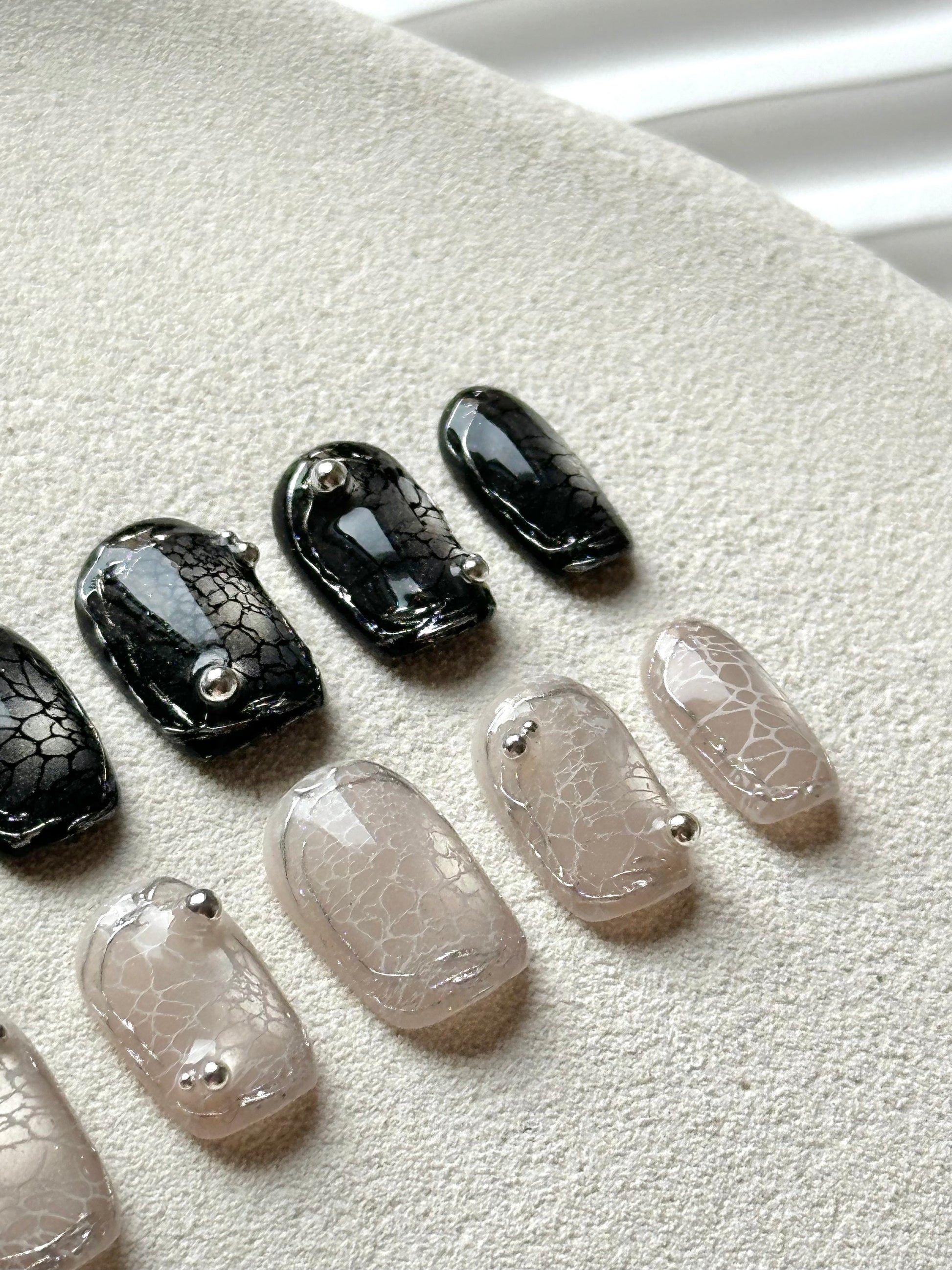 Detailed shot of the 3D silver beads and intricate web texture on a gothic-inspired manicure.